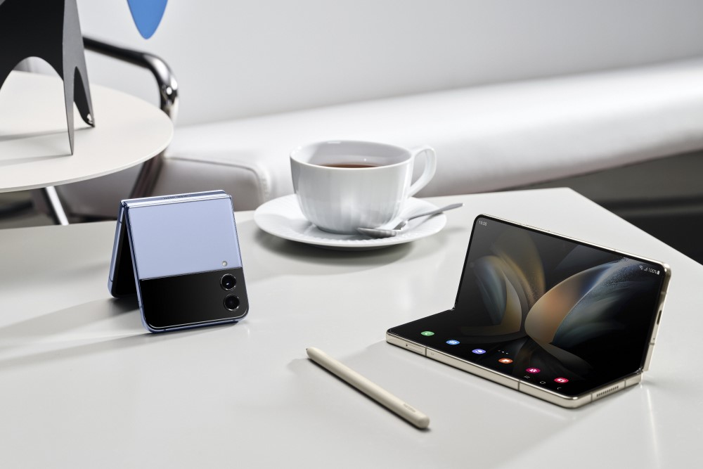 Samsung Galaxy Z Flip4 & Fold4 sitting on a table with S Pen and a cup of coffee.